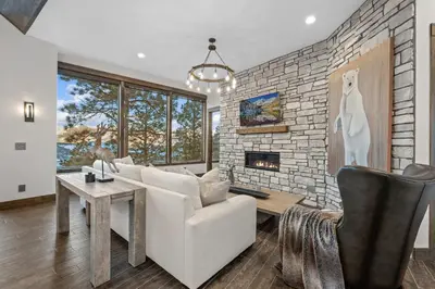 a living room with a white couch and a brick wall at Skyes Peak - Luxury Mountain Retreat with Breathtaking Views in Estes Park
