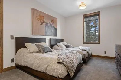 two beds in a bedroom with white walls at Skyes Peak - Luxury Mountain Retreat with Breathtaking Views in Estes Park