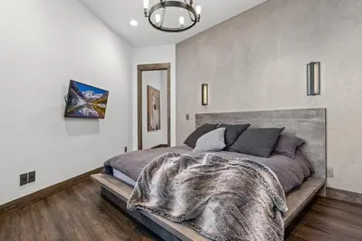 a bedroom with a bed with a blanket on it at Skyes Peak - Luxury Mountain Retreat with Breathtaking Views in Estes Park