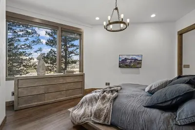 a bedroom with a bed and a large window at Skyes Peak - Luxury Mountain Retreat with Breathtaking Views in Estes Park