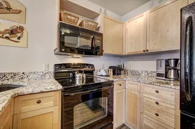 a kitchen with a stove and a microwave at Silver Mill 8167 - 1Br-Walk to Slopes! Kids Ski Free! condo in Keystone