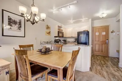 a kitchen with a wooden dining table and chairs at Silver Mill 8167 - 1Br-Walk to Slopes! Kids Ski Free! condo in Keystone