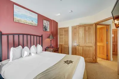 a bedroom with a white bed and a red wall at Silver Mill 8173 - 1Br-Walk to Slopes! Kids Ski Free! condo in Keystone