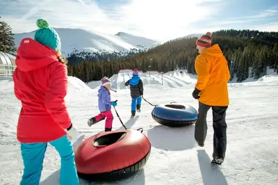 a group of people standing in the snow with tubing at Silver Mill 8173 - 1Br-Walk to Slopes! Kids Ski Free! condo in Keystone