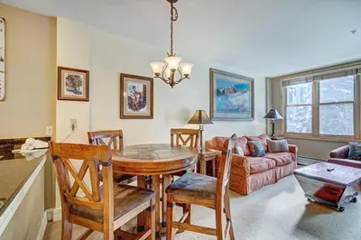 a kitchen and living room with a table and chairs at Silver Mill 8173 - 1Br-Walk to Slopes! Kids Ski Free! condo in Keystone