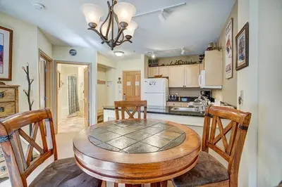 a kitchen with a round wooden table and chairs at Silver Mill 8173 - 1Br-Walk to Slopes! Kids Ski Free! condo in Keystone
