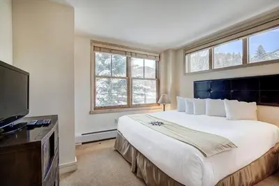 a bedroom with a large bed and a flat screen tv at Silver Mill 8184 - 1Br-Walk to Slopes! Kids Ski Free! condo in Keystone
