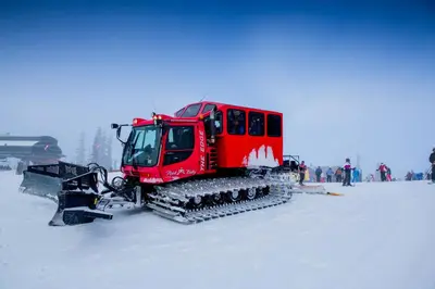 a red snow machine sitting in the snow at Silver Mill 8184 - 1Br-Walk to Slopes! Kids Ski Free! condo in Keystone