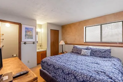 a bedroom with a bed with a blue comforter at Buffalo Ridge B107 in Silverthorne