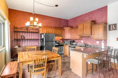 a kitchen with wooden cabinets and a table with chairs at Buffalo Ridge B107 in Silverthorne