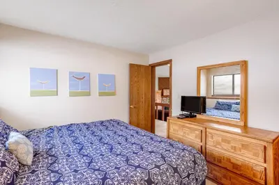 a bedroom with a bed and a tv and a mirror at Buffalo Ridge B107 in Silverthorne