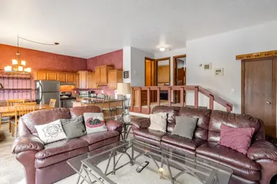 a living room with two leather couches and a kitchen at Buffalo Ridge B107 in Silverthorne