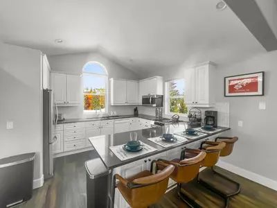 a kitchen with white cabinets and a island with chairs at 928A Lakepoint Circle 3Br 2,5Ba home in Frisco