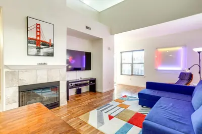 a living room with a blue couch and a fireplace at 4 Mi to Airport Convenient Denver Condo in Aurora