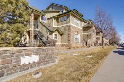 a house with a brick wall in front of a street at 4 Mi to Airport Convenient Denver Condo in Aurora