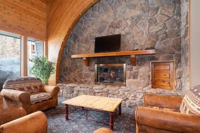 a living room with a stone wall with a fireplace at Silverado II Unit 334 in Winter Park