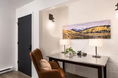 a desk in a room with a painting on the wall at The Modern Mountaineer in Bailey