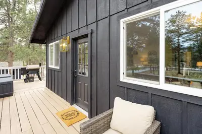 a screened in porch with a door and a bench at The Modern Mountaineer in Bailey