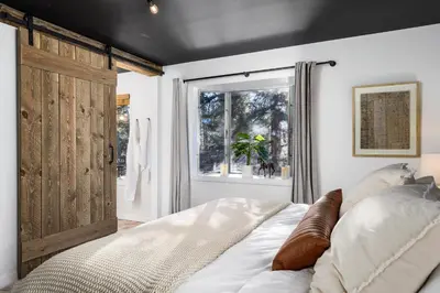 a bedroom with a large bed and a window at The Modern Mountaineer in Bailey