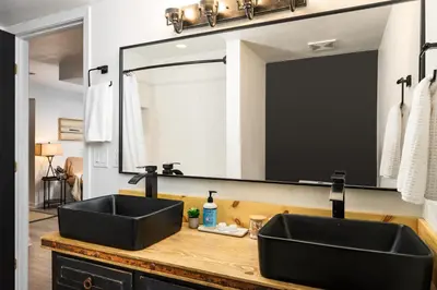 a bathroom with a black sink and a large mirror at The Modern Mountaineer in Bailey