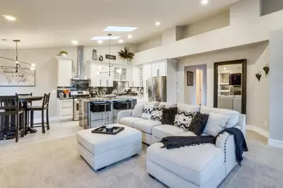 a living room with two white couches and a kitchen at Near Red Rocks Golden Getaway with Deck! in Golden