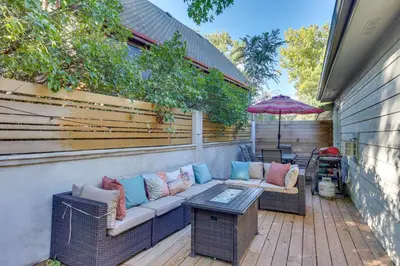 a patio with a couch and a table and an umbrella at Near Red Rocks Golden Getaway with Deck! in Golden