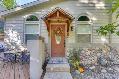 a house with a red door on a wooden porch at Near Red Rocks Golden Getaway with Deck! in Golden