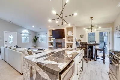 a kitchen and living room with a large marble counter top at Near Red Rocks Golden Getaway with Deck! in Golden