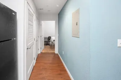 a hallway with blue walls and wooden floors at Fully Furnished 2BR Centrally Located with Pool in Greeley