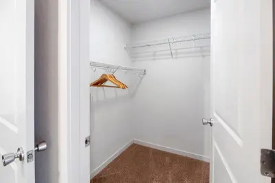 a walk in closet with white walls and a door at Fully Furnished 2BR Centrally Located with Pool in Greeley