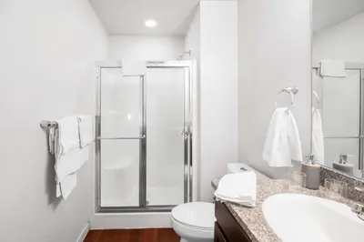 a bathroom with a shower and a toilet and a sink at Fully Furnished 2BR Centrally Located with Pool in Greeley