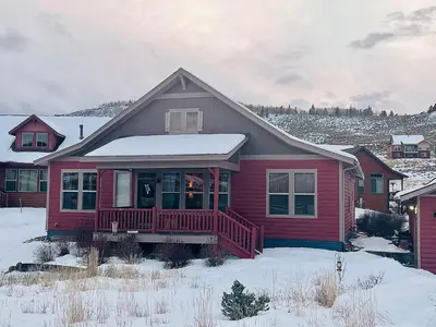 a red house with a porch in the snow at Granby Ranch Ski & Golf Getaway - Pank's Peak in Granby