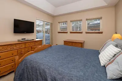 a bedroom with a bed and a flat screen tv at Telemark Townhomes Unit 514 in Winter Park