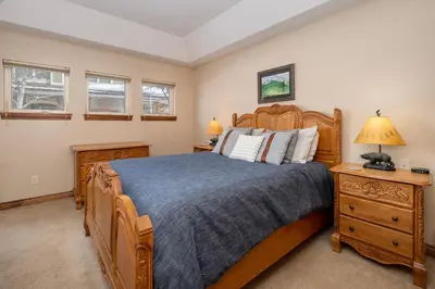 a bedroom with a wooden bed and a nightstand at Telemark Townhomes Unit 514 in Winter Park