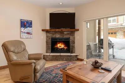 a living room with a fireplace with a television at Telemark Townhomes Unit 514 in Winter Park