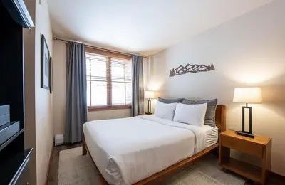 a bedroom with a large white bed and a window at Secluded Condo with Corridor Ski Trail View - Zephyr Mountain Lodge Premium Unit 1201 condo in Winter Park