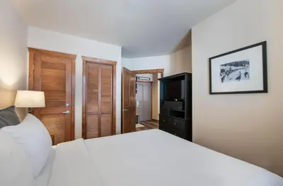 a bedroom with a white bed and a television at Secluded Condo with Corridor Ski Trail View - Zephyr Mountain Lodge Premium Unit 1201 condo in Winter Park
