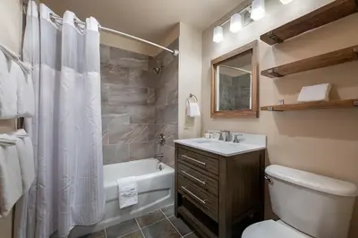 a bathroom with a toilet and a tub and a sink at Secluded Condo with Corridor Ski Trail View - Zephyr Mountain Lodge Premium Unit 1201 condo in Winter Park