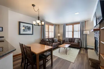 a dining room and living room with a table and chairs at Secluded Condo with Corridor Ski Trail View - Zephyr Mountain Lodge Premium Unit 1201 condo in Winter Park