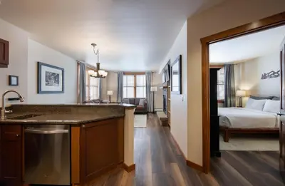 a kitchen with a sink and a bedroom with a bed at Secluded Condo with Corridor Ski Trail View - Zephyr Mountain Lodge Premium Unit 1201 condo in Winter Park