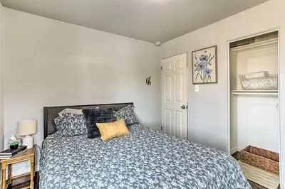a bedroom with a bed with a blue comforter at 3 Mi to Empower Field Denver Home with Fire Pit in Denver