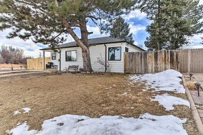 a house with a tree in a yard with snow at 3 Mi to Empower Field Denver Home with Fire Pit in Denver