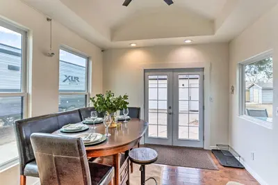 a dining room with a table and chairs and windows at 3 Mi to Empower Field Denver Home with Fire Pit in Denver