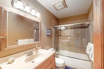 a bathroom with a sink and a shower with a mirror at High Country Nest in Winter Park- Unit 16 in Winter Park