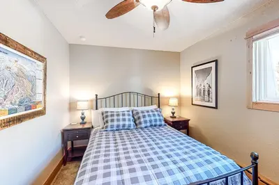 a bedroom with a bed with two night stands and two windows at High Country Nest in Winter Park- Unit 16 in Winter Park