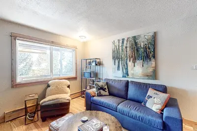 a living room with a blue couch and a table at High Country Nest in Winter Park- Unit 16 in Winter Park