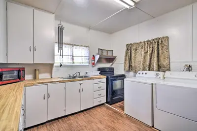 a kitchen with white cabinets and a sink and a stove at Pet-Friendly Loveland Vacation Rental! in Loveland