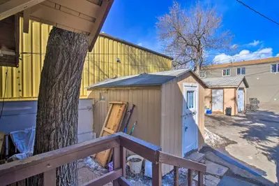 a wooden shed with a tree next to a building at Pet-Friendly Loveland Vacation Rental! in Loveland