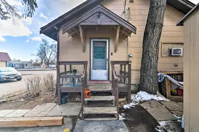 a house with a porch with a door and a tree at Pet-Friendly Loveland Vacation Rental! in Loveland