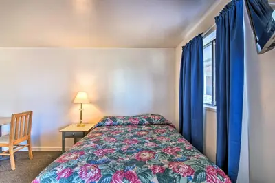 a bedroom with a bed and a window with blue curtains at Vacation Rental in Loveland 1 Mi to Downtown! in Loveland